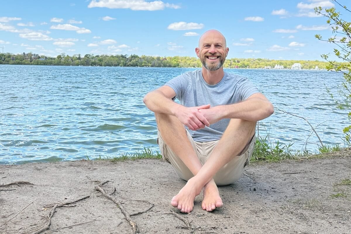 Joel Zaslofsky sitting on the shore of Lake Harriet