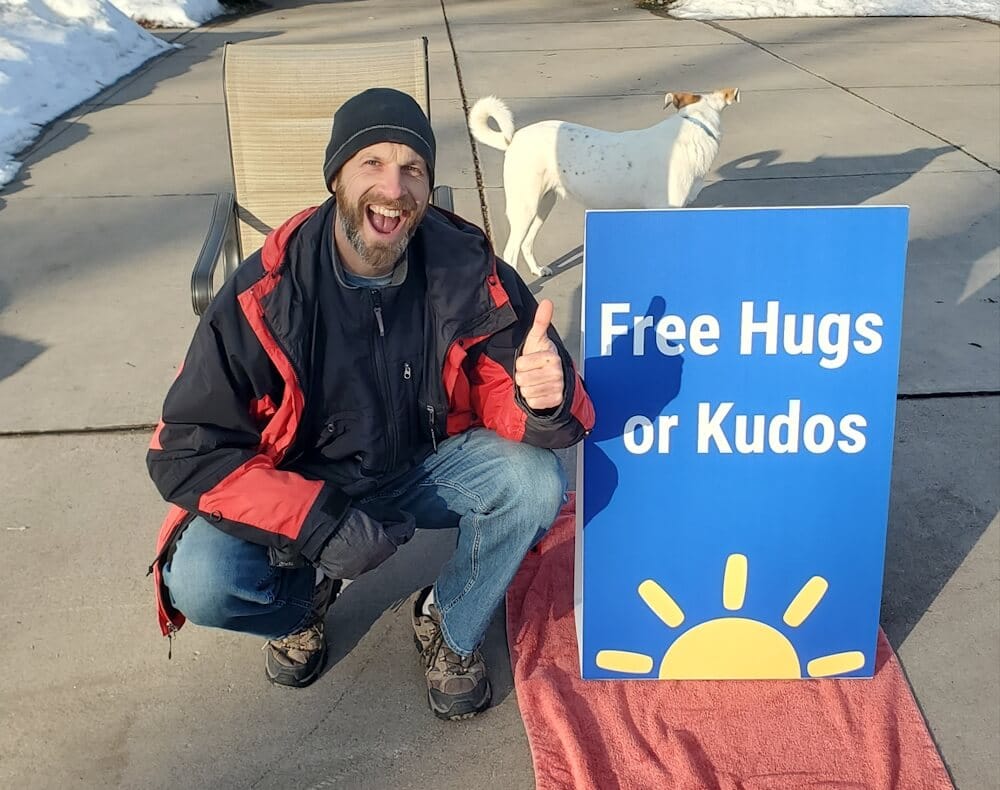 Joel Zaslofsky with Custom Free Hugs and Kudos Sign at End of His Driveway